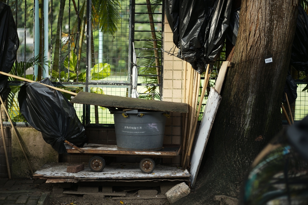 ELCAN 66mm f/2 photo sample — a Food and Environmental Hygiene Department handcart and bamboo poles against railings